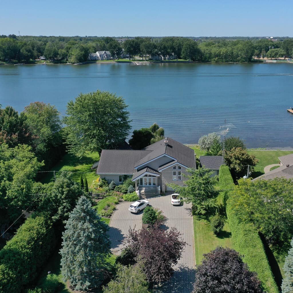 Exemple de prise de vue aérienne par drone d'une maison à vendre sur le bord de l'eau pour photographie drone immobilier