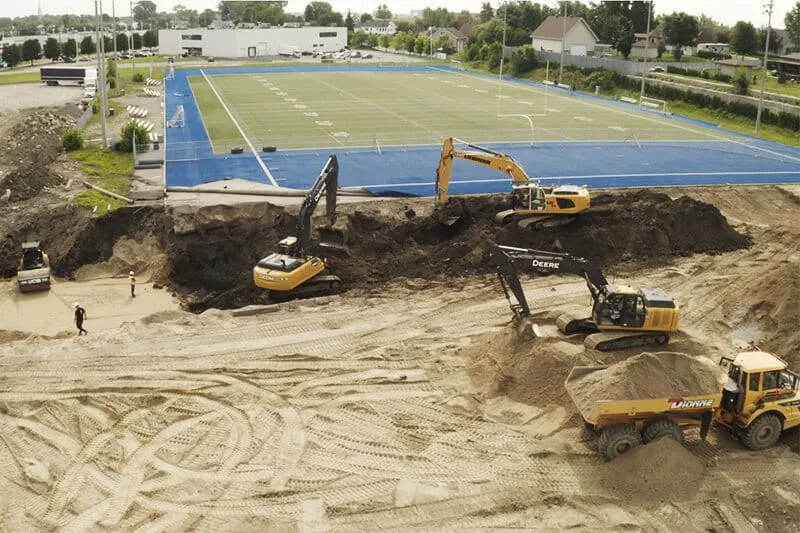L'image montre un drone survolant un site de construction, capturant des images détaillées de l'avancement des travaux.